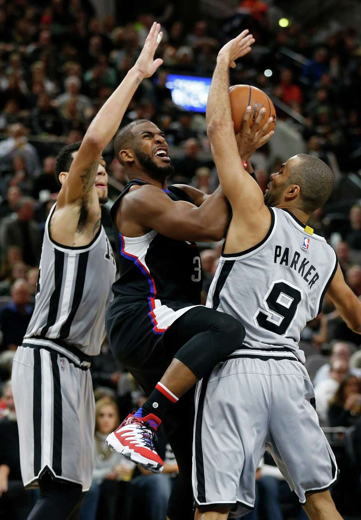 Spurs' Tony Parker (09) and Danny Green (14) pressure Clippers' Chris Paul (03) at the AT&T Center on Friday, Dec. 18, 2015. (Kin Man Hui/San Antonio Express-News)