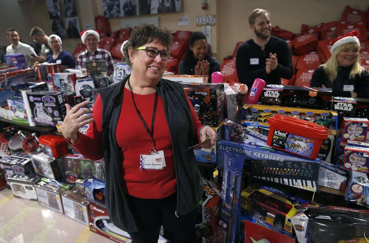 Laurrie Ferreira leads volunteers who escort children through the toys at the annual toy giveaway at Glide Memorial Church in San Francisco on Saturday, Dec. 19, 2015.