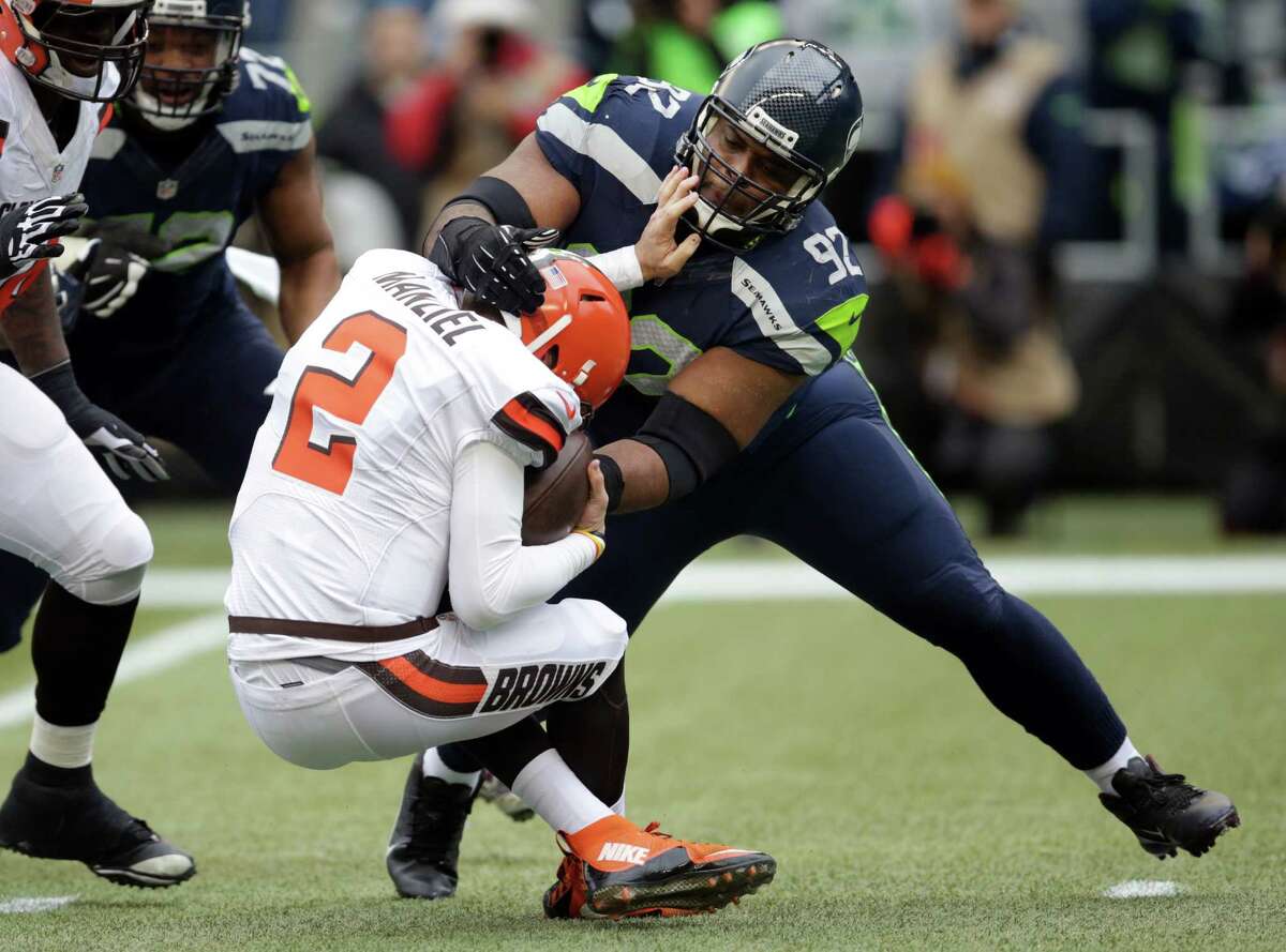 Seattle Seahawks' Brandon Mebane brings down Cleveland Browns quarterback Johnny Manziel in the first half of an NFL football game, Sunday, Dec. 20, 2015, in Seattle.
