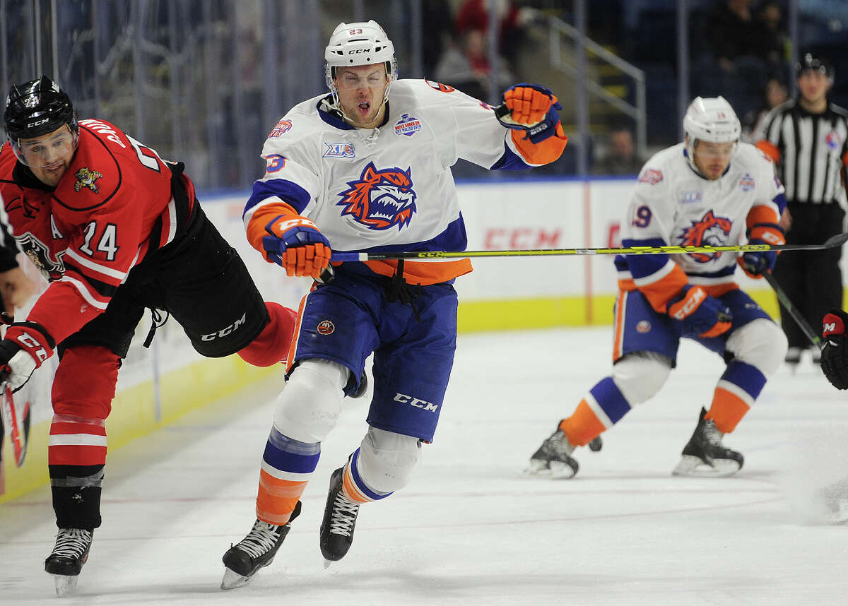 Portland's Sena Acolatse' left, and Sound Tiger James Wright chase the puck up ice during the first period of their AHL hockey game at the Webster Bank Arena in Bridgeport, Conn. on Sunday, December 20, 2015.
