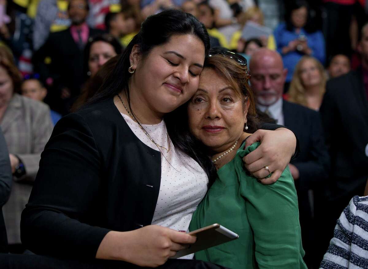 In this Nov. 21, 2014 file photo, Lorella Praeli, left, and her mother Chela Praeli, embrace as President Barack Obama speaks about immigration, at Del Sol High School in Las Vegas. The Hillary Clinton presidential campaign announced Wednesday, May 20, 2015 that Lorella Praeli has been named their Latino Outreach director. (AP Photo/Carolyn Kaster, File)
