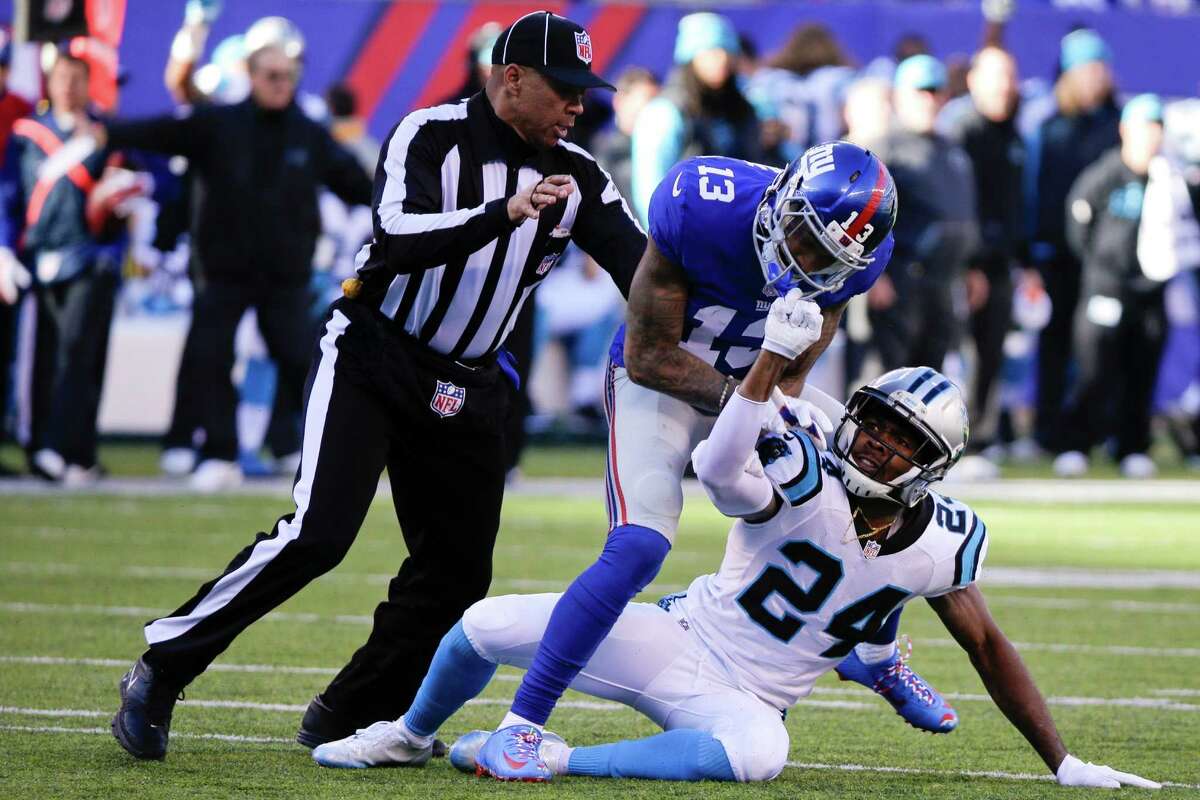 A referee, left, separates New York Giants wide receiver Odell Beckham (13) and Carolina Panthers' Josh Norman (24) during the first half of an NFL football game Sunday, Dec. 20, 2015, in East Rutherford, N.J. (AP Photo/Julie Jacobson)