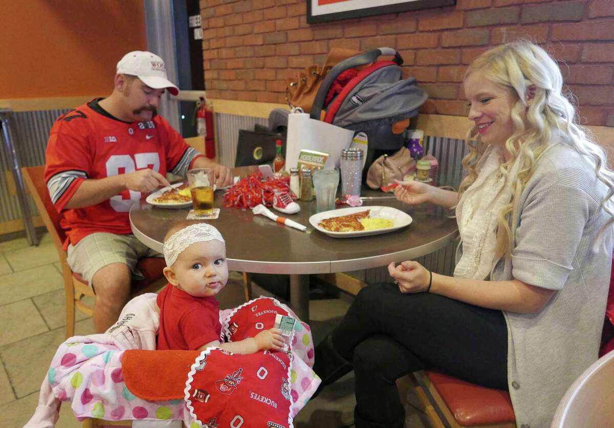 Valerie Bowen, right, and her daughter, Audrey, and husband, Chris, attend the Kegs and Eggs breakfast gathering of The Ohio State University football fans at Buffalo Wings & Rings on Loop 1604 on Saturday, Nov. 28, 2015.