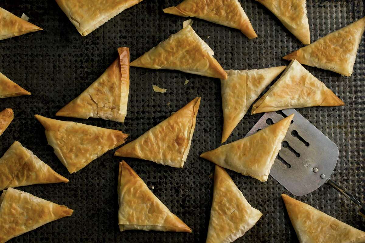Baked Greek phyllo triangles filled with roast winter squash mixed with sauteed scallions and garlic, a generous amount of mint, feta and egg, in New York, Nov. 25, 2015. The crispy filled pastries are always impressive, and while they take some time to make, they are not at all difficult. (Andrew Scrivani/The New York Times) ORG XMIT: XNYT24 ORG XMIT: MER2015121816391652