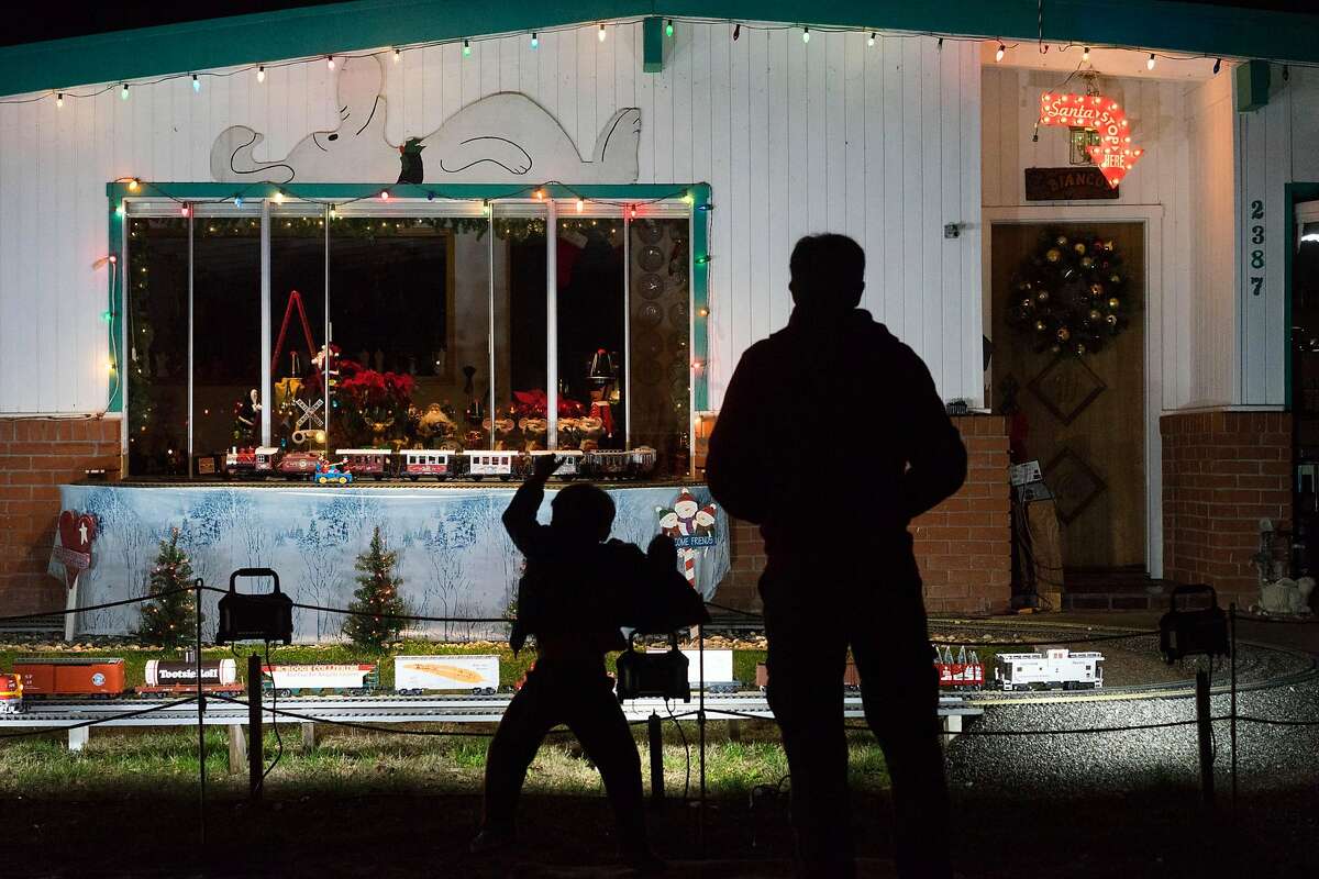 Gavin Bayer, left, and his father James watch John Bianco's train display in Mountain View, Calif on Tuesday, Dec. 22, 2015. The Bianco family has brought together residents of Mountain View and beyond with their annual model train display.