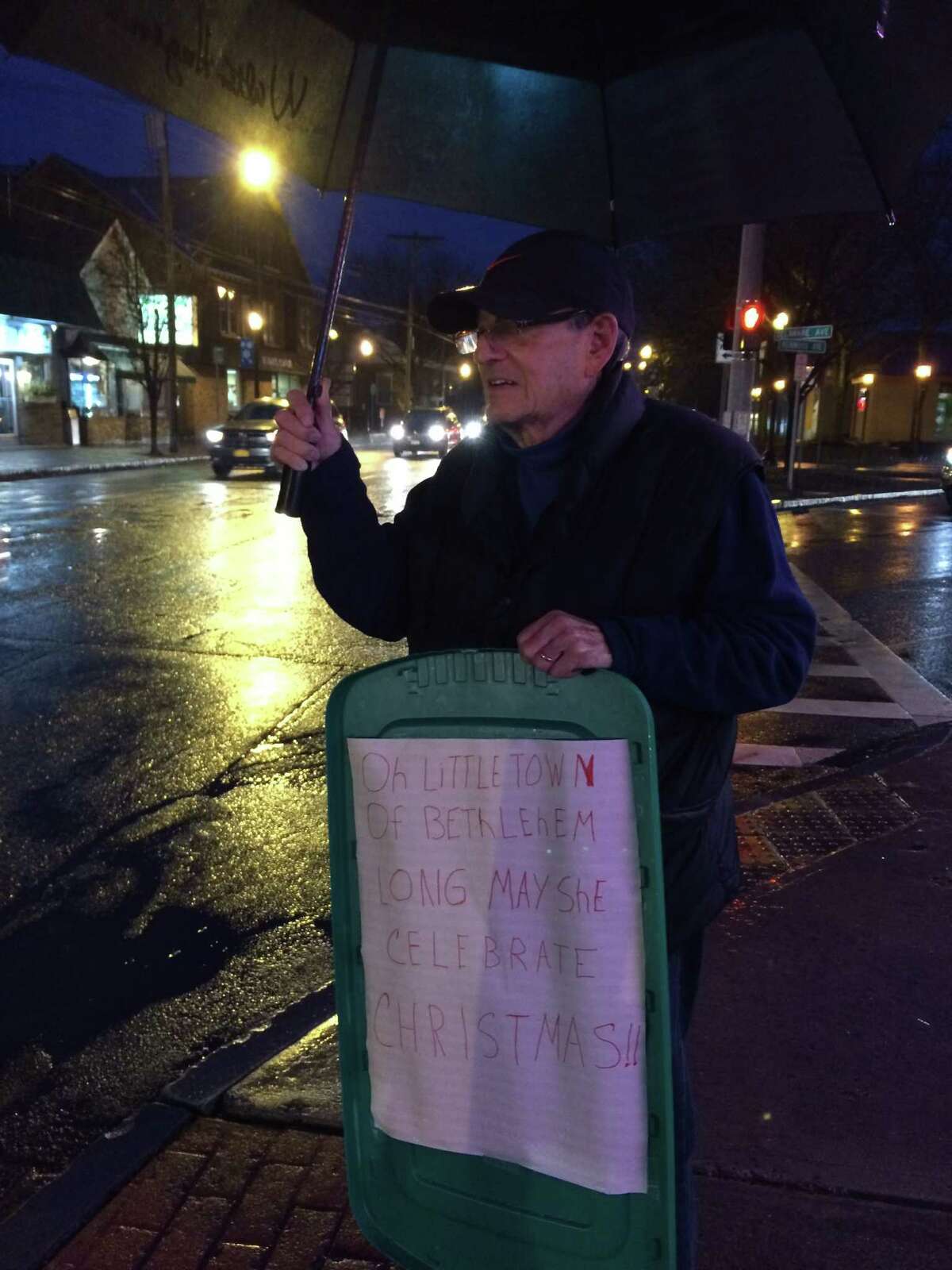 A man carries at sign at the Delmar Four Corners in protest of the town of Bethlehem's decision not to have religious holiday signs at the busy intersection. (Lauren Stanforth / Times Union)
