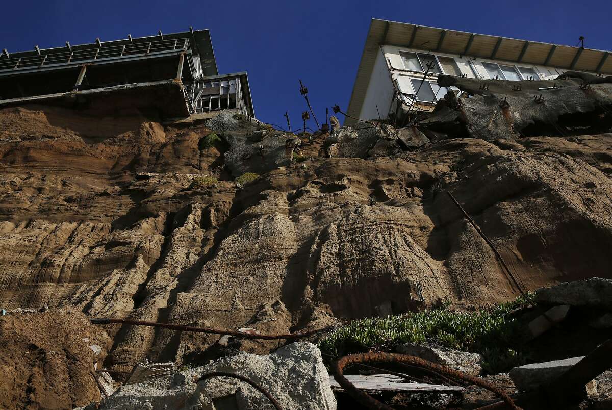Properties on 330, right, and 320 Esplanade Ave perch on the edge of an eroding cliff with debris below them Dec. 23, 2015 in Pacifica, Calif. Both properties are vacant.