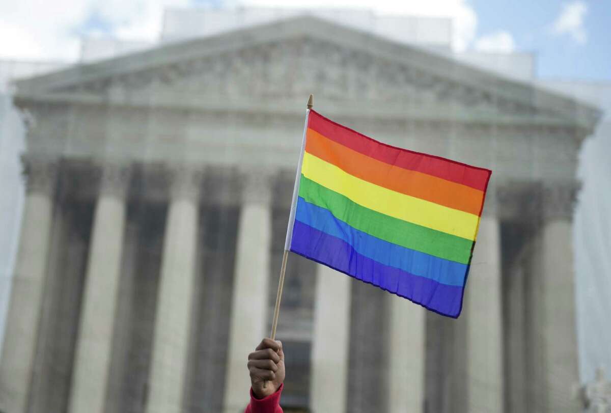 A same-sex marriage supporter waves a rainbow flag in front of the US Supreme Court on March 26, 2013 in Washington, DC, as the Court takes up the issue of gay marriage. The US Supreme Court on Tuesday heard arguments on the emotionally charged issue of gay marriage as it considers arguments that it should make history and extend equal rights to same-sex couples. Waving US and rainbow flags, hundreds of gay marriage supporters braved the cold to rally outside the court along with a smaller group of opponents, some pushing strollers. Some slept outside in hopes of witnessing the historic hearing. AFP PHOTO / Saul LOEBSAUL LOEB/AFP/Getty Images