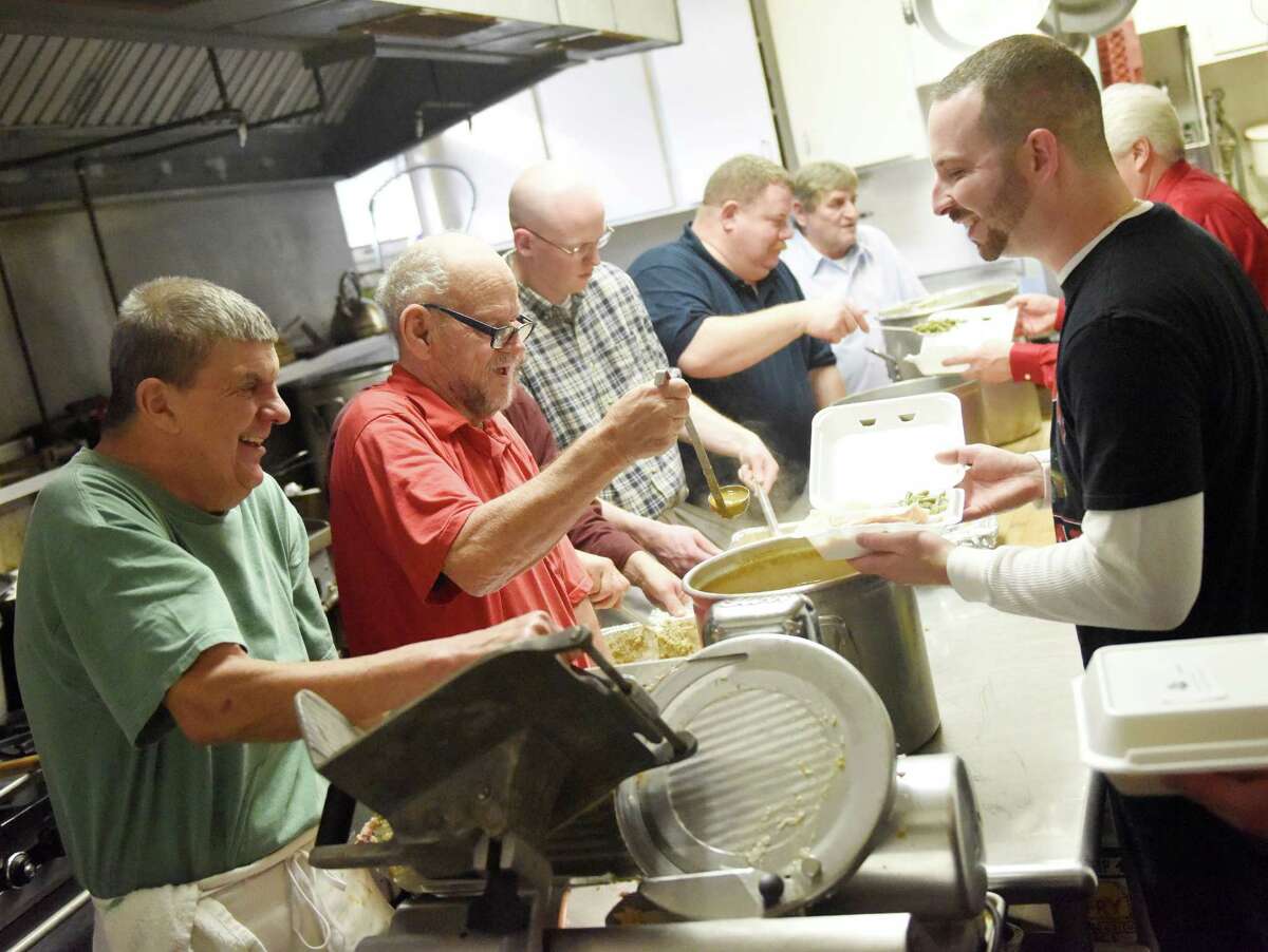 Knights of Columbus members Ed Cofone, left, Willie Kolok, center, and Bill Zand, right, package delivery meals during the annual Christmas community lunch at the Knights of Columbus headquarters in Greenwich, Conn. Friday, Dec. 25, 2015. About 30 volunteers helped serve 70 local seniors in the headquarters' dining room and about 75 meal home deliveries were made on Christmas Day.