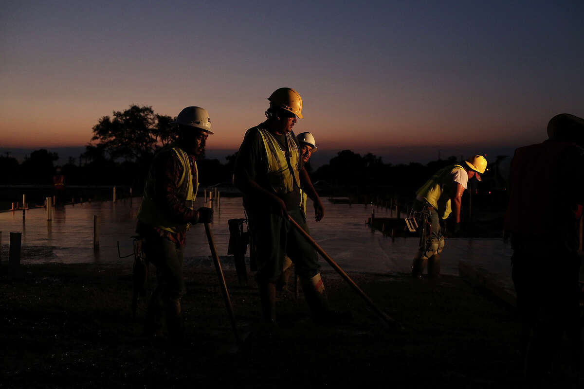 An SLS crew works to finish a freshly poured concrete foundation for apartment buildings at Wheatley Courts in San Antonio before sunrise on Friday, August 14, 2015.