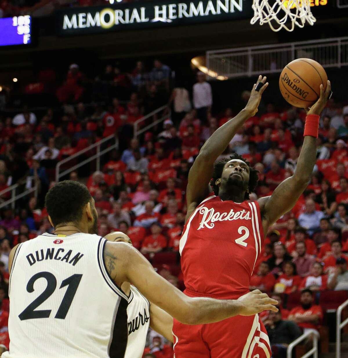 Houston Rockets guard Patrick Beverley (2) drives to the basket against San Antonio Spurs guard Tony Parker, rear, and center Tim Duncan (21) in the first half of an NBA basketball game Friday, Dec. 25, 2015, in Houston. (AP Photo/Bob Levey)