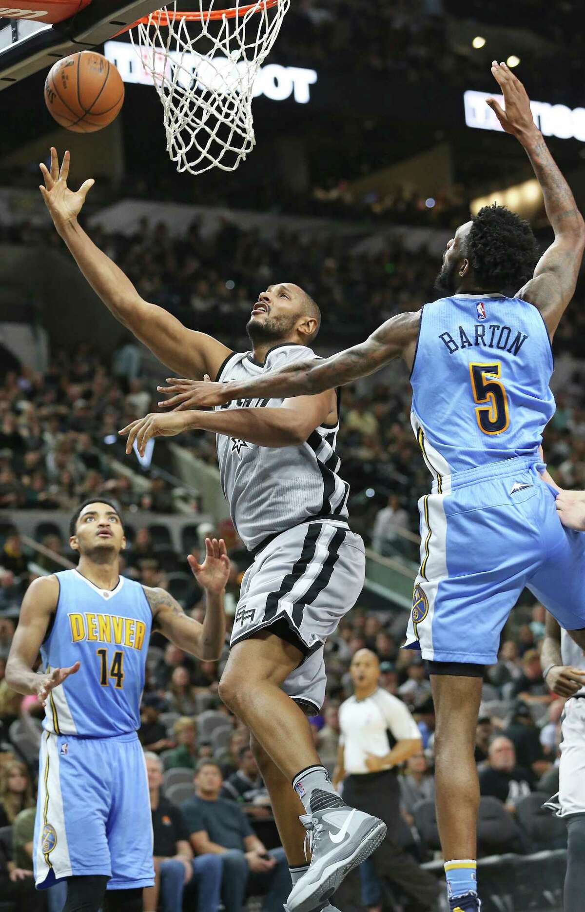 Boris Diaw floats through to get a running layup between Gary Harris (14) and Will Barton as the Spurs host the Denver Nuggets at the AT&T Center on Dec. 27, 2015.