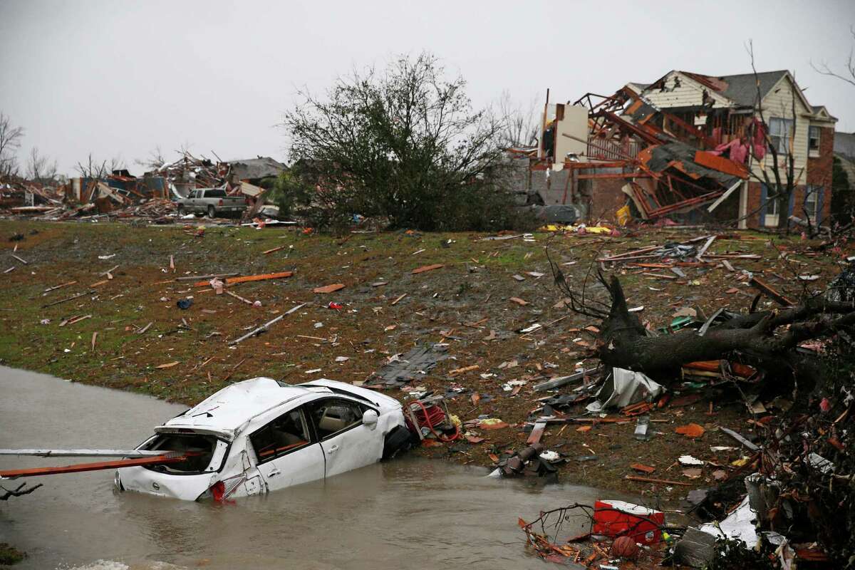 A car is flooded in a drainage ditch after Saturday's tornado on Schrade Road in Rowlett, Texas, Sunday, Dec. 27, 2015. At least 11 people died and dozens were injured in apparently strong tornadoes that swept through the Dallas area and caused substantial damage this weekend. (Nathan Hunsinger/The Dallas Morning News via AP)
