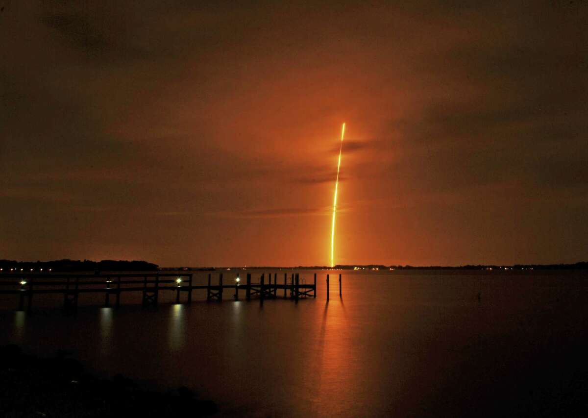 The SpaceX Falcon 9 launch appears in the distance from the back of River Rocks dockside restaurant along the Indian River, south of Rockledge. Fla., Monday, Dec. 21, 2015. SpaceX sent the rocket soaring toward orbit with 11 small satellites, its first mission since an accident last summer. (Tim Shortt/Florida Today via AP)
