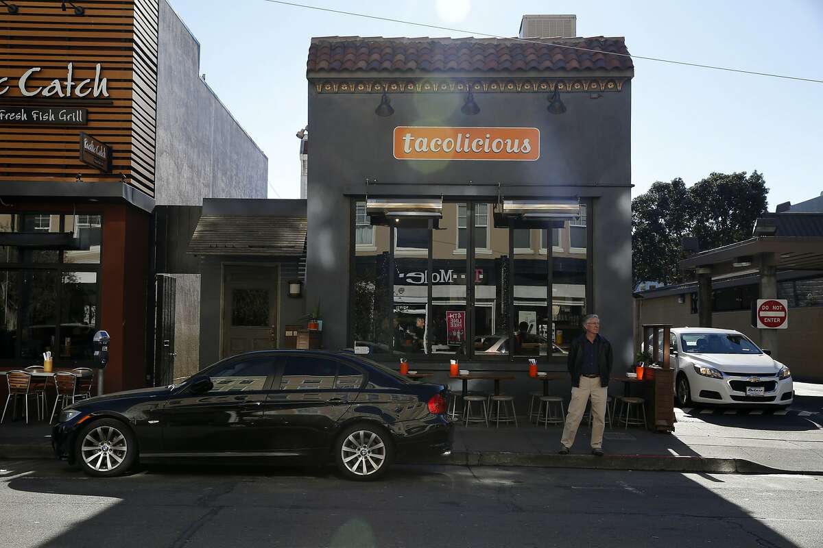 A man stands near a parked car outside Tacolicious on Chestnut Street in San Francisco, California, on Tuesday, Dec. 29, 2015.