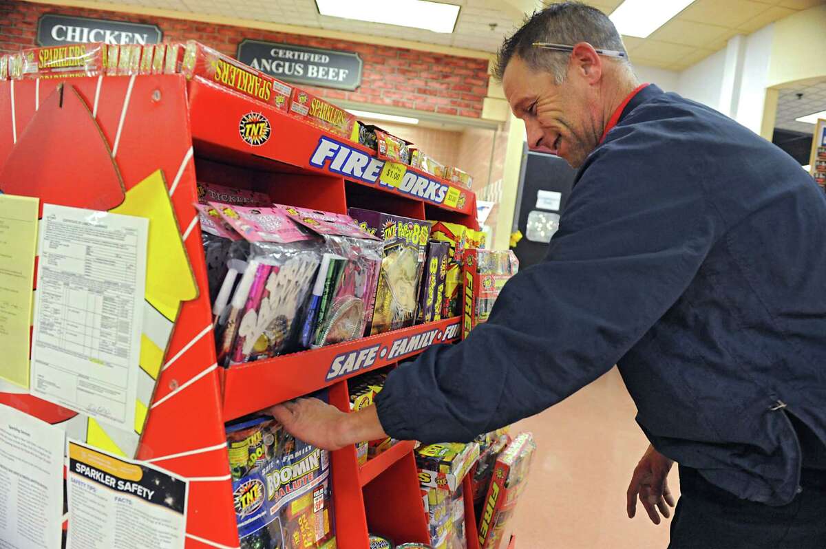 Grocery Manager John Halligan straightens up a display of fireworks at Price Chopper on Hoosick Rd. on Tuesday, Dec. 29, 2015 in Brunswick, N.Y. Warren County, where Lake George is located, is considering banning fireworks sales after 2021. (Lori Van Buren / Times Union)