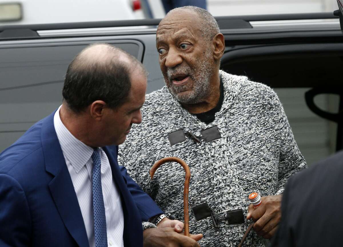 Actor and comedian Bill Cosby is helped as he arrives for a court appearance to face a felony charge of aggravated indecent assault Wednesday, Dec. 30, 2015, in Elkins Park, Pa. Cosby was arrested and charged Wednesday with drugging and sexually assaulting a woman at his home 12 years ago. (AP Photo/Mel Evans)