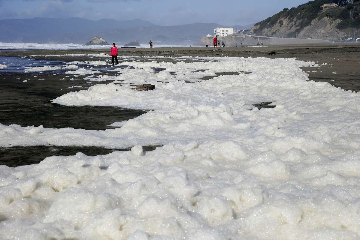 Foam from a storm surge washes up on shore on Ocean Beach Friday, Dec. 11, 2015, in San Francisco. A high surf warning remains in place in Northern California. The National Weather Service says the biggest storm of the season should quiet down in the Sierra Nevada before kicking back up Saturday. (AP Photo/Marcio Jose Sanchez)