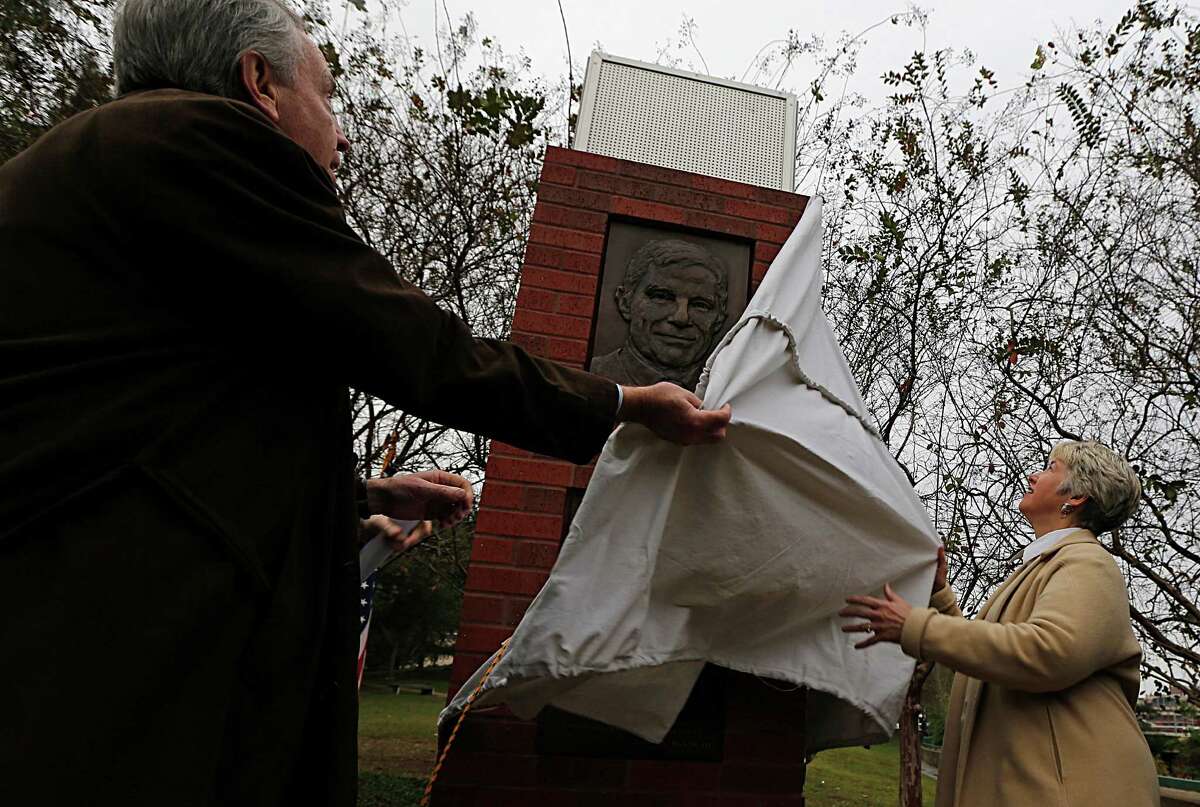 Davis Jones left, and Mayor Annise Parker right, unveil one of two bronze relief panels depicting former U.S. Commerce Secretary Robert Mosbacher, Sr. during the gifting ceremony, the commemorative panels are located near the Preston Street Bridge in Sesquicentennial Park Wednesday, Dec. 30, 2015, in Houston. The bridge has been renamed as the Robert A. Mosbacher, Sr., Memorial Bridge.