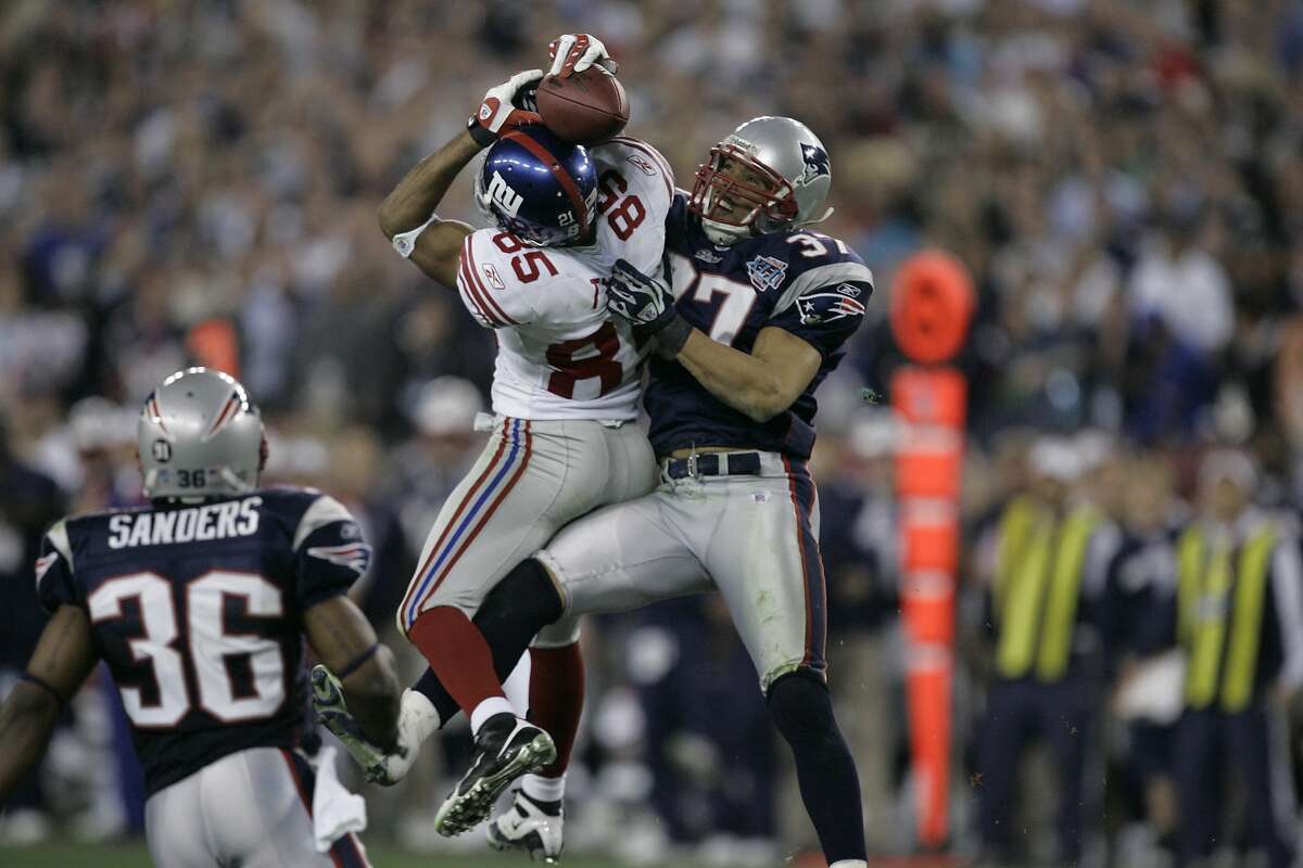 New York Giants receiver David Tyree (85) catches a 32 yard pass in the clutches of New England Patriots safety Rodney Harrison (37) during the fourth quarter of the Super Bowl XLII football game at University of Phoenix Stadium on Sunday, Feb. 3, 2008 in Glendale, Ariz. (AP Photo/Gene Puskar)
