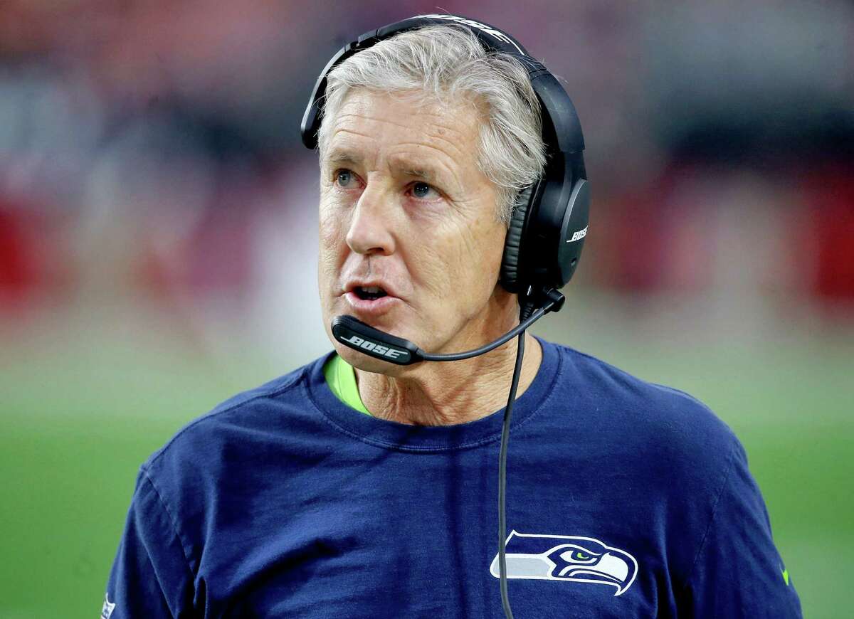 Seattle Seahawks head coach Pete Carroll makes a call during the first half of an NFL football game against the Arizona Cardinals, Sunday, Jan. 3, 2016, in Glendale, Ariz. (AP Photo/Ross D. Franklin)