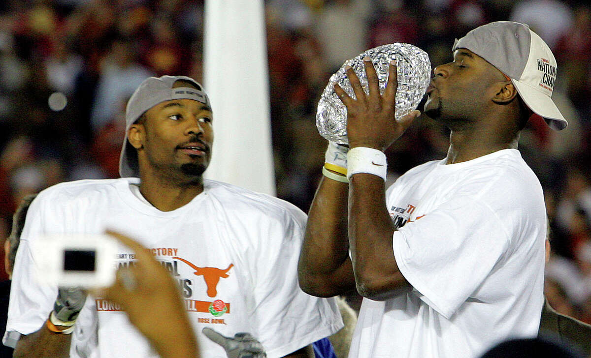 SPORTS - Vince Young kisses the national championship trophy as teammate Michael Huff watches after the Rose Bowl Wednesday, January 4, 2006 at Rose Bowl Stadium in Pasadena. The Longhorns won on a last-minute touchdown by Vince Young. BAHRAM MARK SOBHANI/STAFF TEXAS LONGHORNS SOUTHERN CALIFORNIA TROJANS USC NATIONAL CHAMPIONSHIP BCS