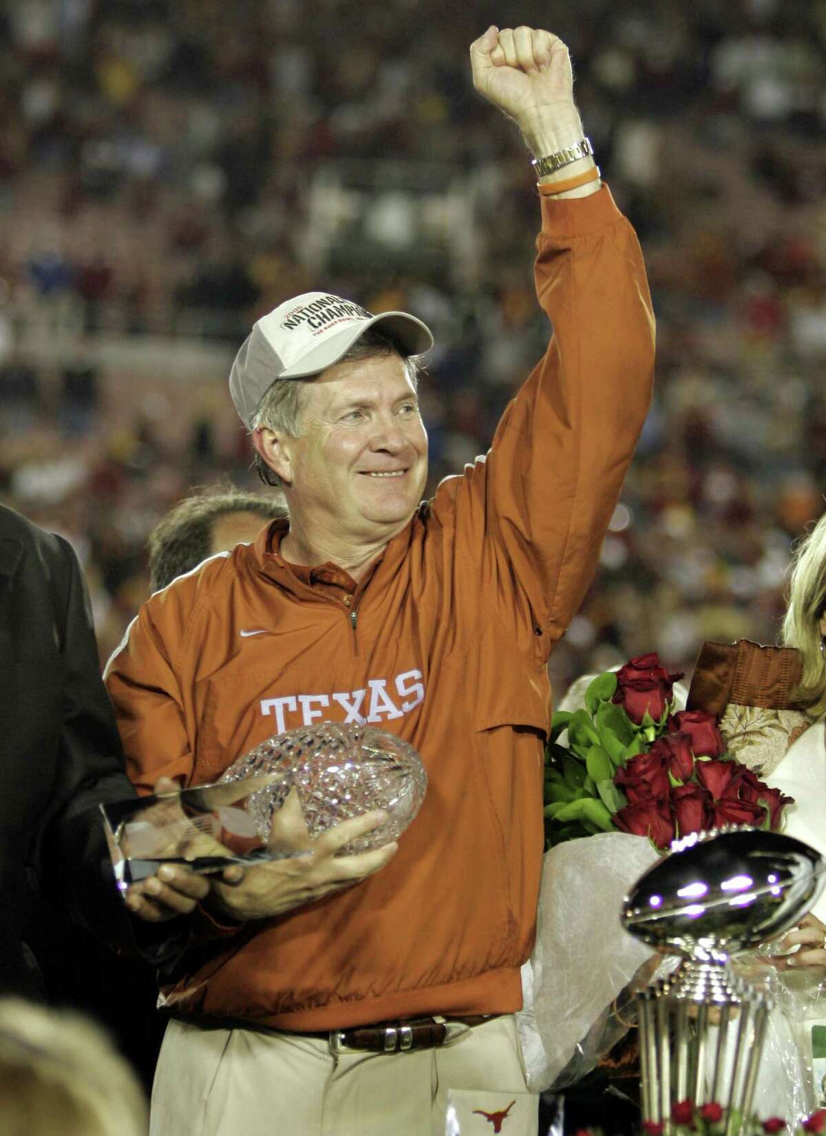 FILE - In this Jan. 4, 2006, file photo, Texas head coach Mack Brown celebrates with the championship trophy after Texas beat Southern California 41-38 in the Rose Bowl, the national championship college football game in Pasadena, Calif. Brown has stepped down as coach and that the Alamo Bowl against Oregon on Dec. 30 will be his last game with the Longhorns, the school announced Saturday, Dec. 14, 2013. (AP Photo/ Mark J. Terrill, File)