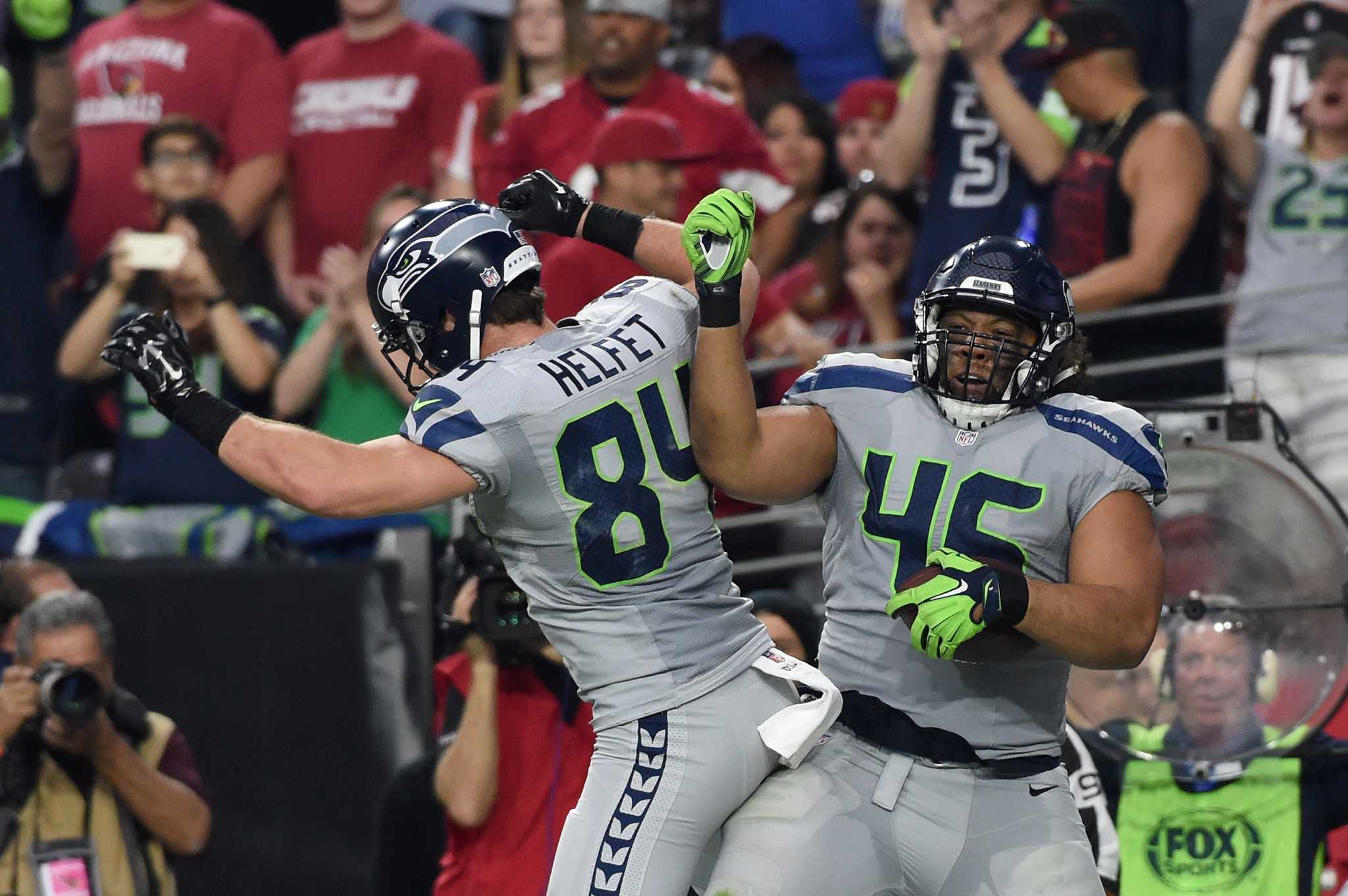 Seattle Seahawks strong safety Kam Chancellor (31)(R) celebrates his  interception with free safety Earl Thomas (29) with cornerback Richard  Sherman (25) and outside linebacker K.J. Wright (50) near by during the  first