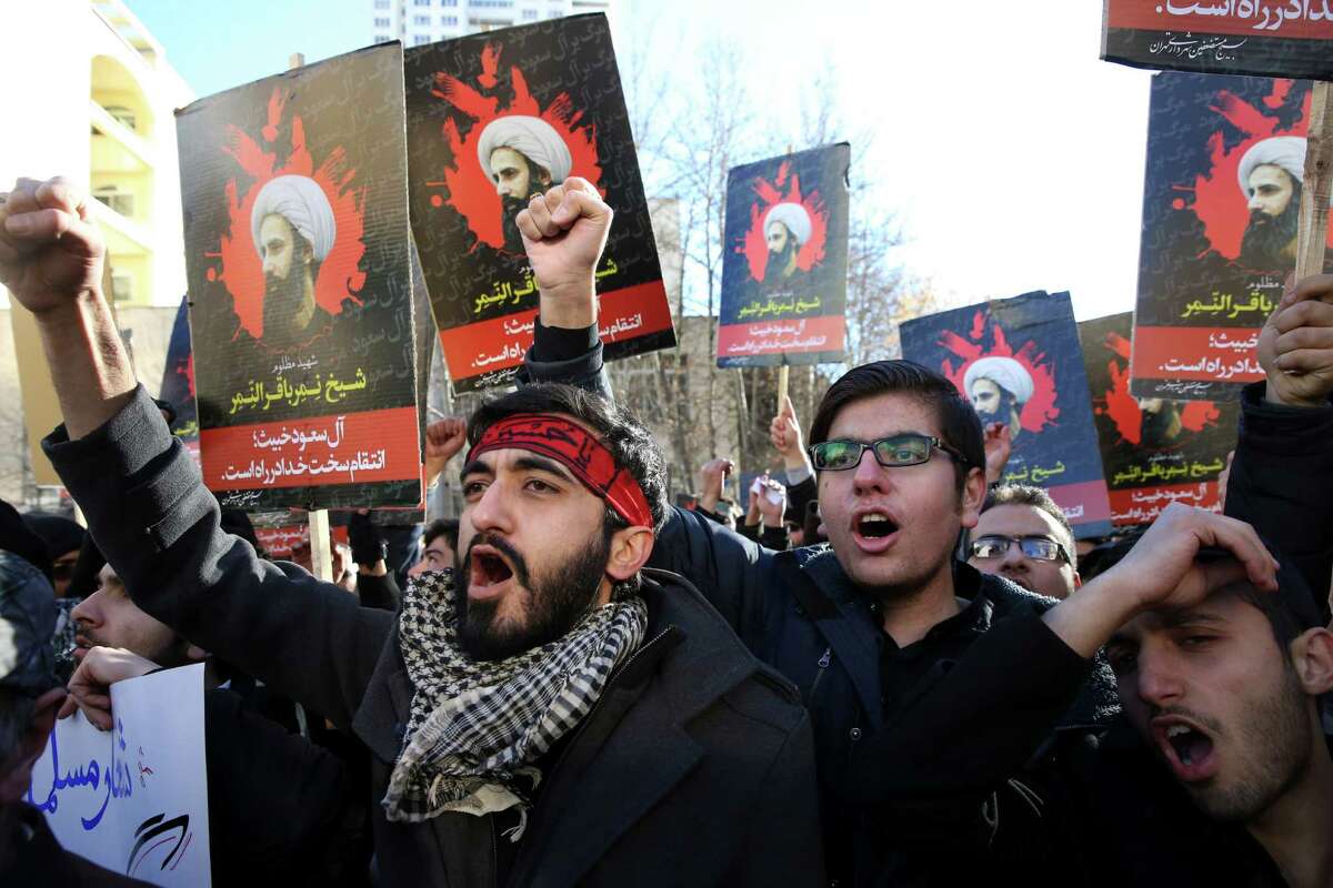 Iranian demonstrators chant slogans during a protest against the execution of Sheikh Nimr al-Nimr, shown in posters, a prominent opposition Shiite cleric in Saudi Arabia, in front of the Saudi Embassy, in Tehran, Sunday, Jan. 3, 2016. Saudi Arabia announced the execution of al-Nimr on Saturday along with 46 others. Al-Nimr was a central figure in protests by Saudi Arabia's Shiite minority until his arrest in 2012, and his execution drew condemnation from Shiites across the region. (AP Photo/Vahid Salemi) ORG XMIT: VAH105