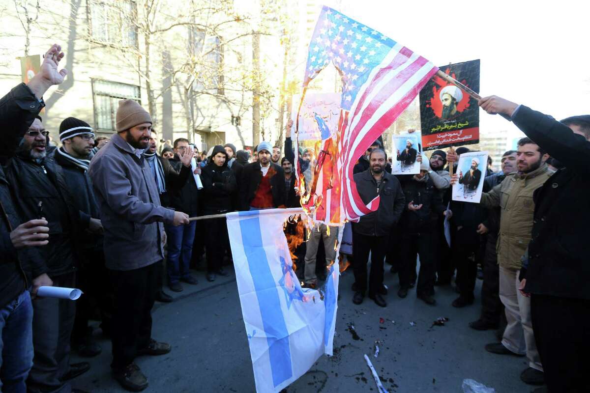 Iranian men burn Israeli and American flags during a demonstration against the execution of prominent Shiite Muslim cleric Nimr al-Nimr by Saudi authorities, on January 3, 2016, outside the Saudi embassy in Tehran. Iran and Iraq's top Shiite leaders condemned Saudi Arabia's execution of Nimr, warning ahead of protests that the killing was an injustice that could have serious consequences. AFP PHOTO / ATTA KENAREATTA KENARE/AFP/Getty Images