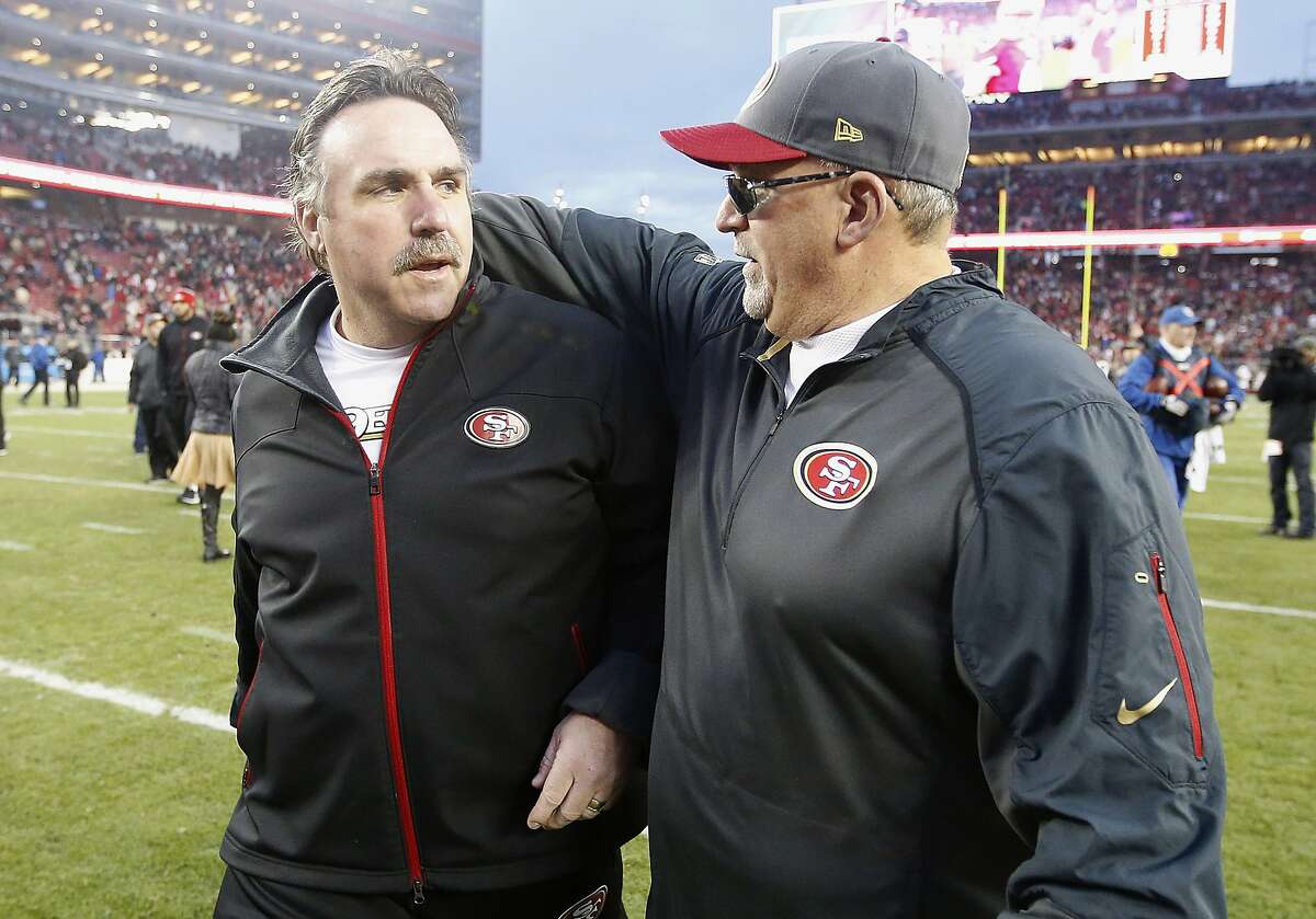 San Francisco 49ers head coach Jim Tomsula, left, walks off the field with tight ends coach Tony Sparano after an NFL football game against the St. Louis Rams in Santa Clara, Calif., Sunday, Jan. 3, 2016. The 49ers won 19-16 in overtime. (AP Photo/Tony Avelar)