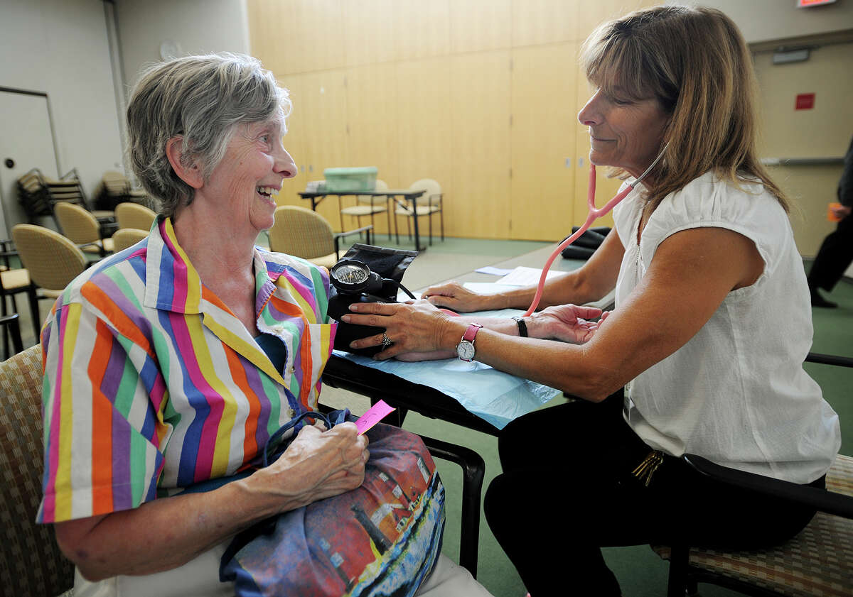 Gerda Eichhorst, left, of Ansonia, receives a free blood pressure check by Diane Frankel-Gramelis at Milford Hospital in Milford, Conn. on Monday, July 21, 2014. Milford Hospital is hosting a health screening this month.
