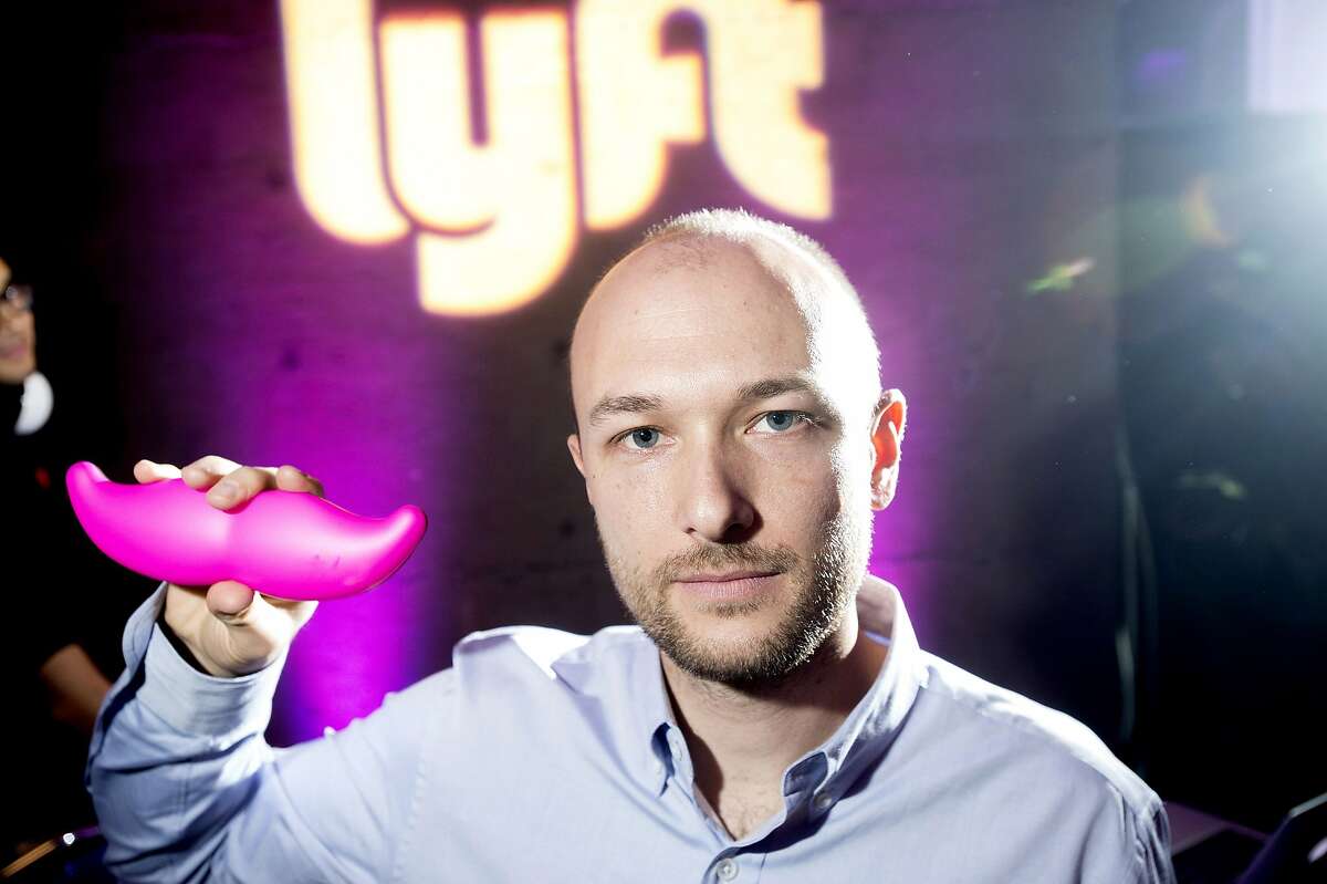 FILE - In this Monday, Jan. 26, 2015, file photo, Logan Green, co-founder and chief executive officer of Lyft, displays his company's "glowstache" during a launch event in San Francisco. On Monday, Jan. 4, 2016, General Motors Co. announced it is investing $500 million in ride-sharing company Lyft Inc. GM gets a seat on Lyft's board as part of the partnership, which could speed the development of on-demand, self-driving cars. (AP Photo/Noah Berger, File)