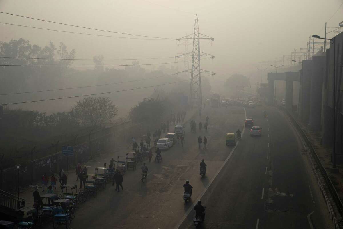 Smog envelops a roadway recently during an experiment to cut traffic to fight pollution in New Delhi, India.