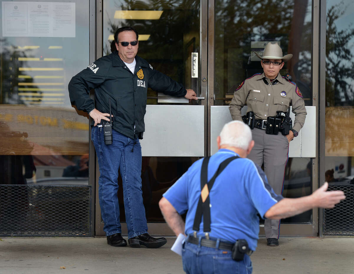 Federal and State law enforcement turn citizens away from the office of Tony Yzaguirre Jr. who is the Cameron County Tax Assessor Collector, Wednesday, Jan. 6,2015 in Brownsville, Texas. State and Federal agents raided the office. Yzaguirre has been arrested and charged with bribery, organized crime and official oppression, says District Attorney Luis V. Saenz. (Brad Doherty/Brownsville Herald via AP)