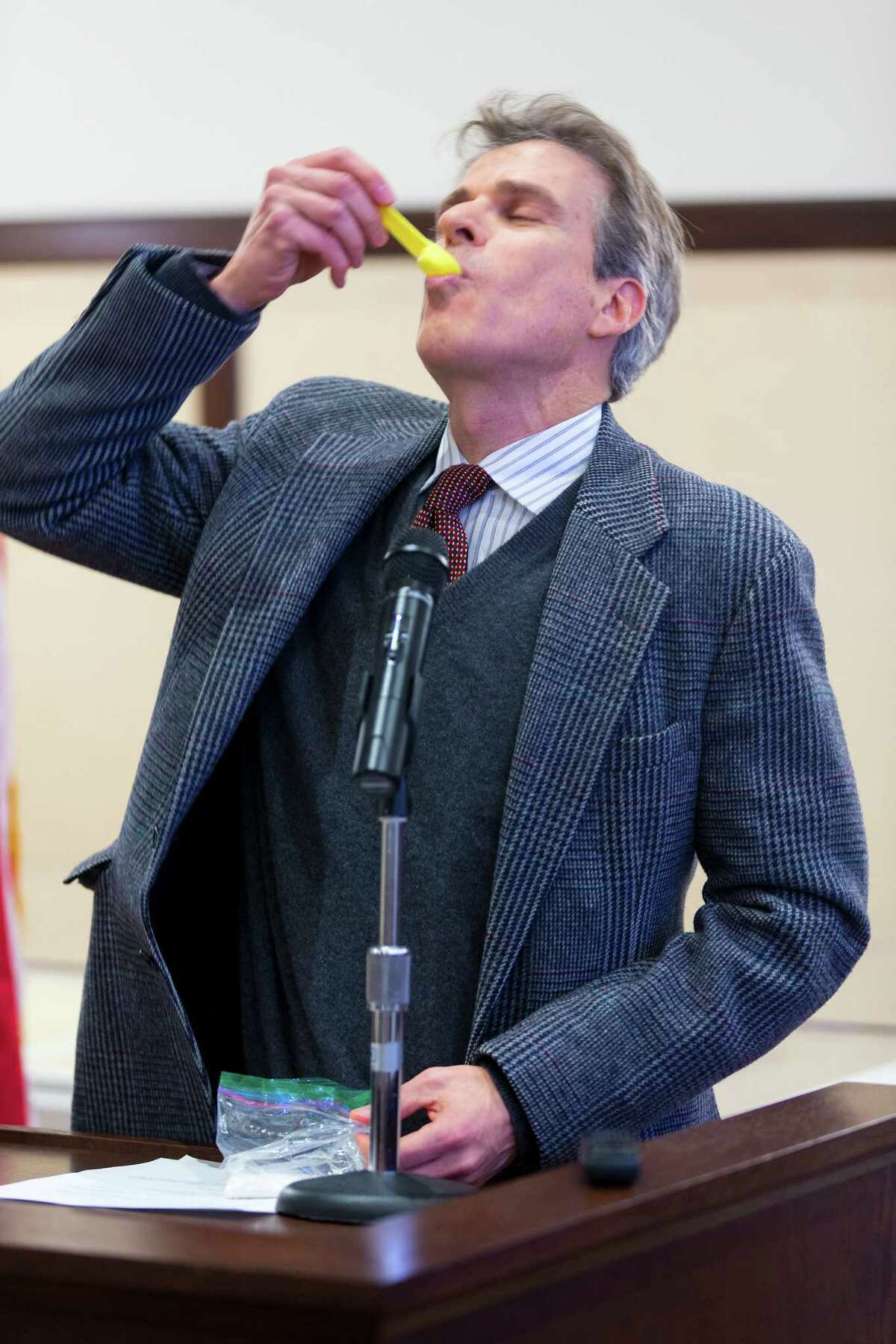 Dr. Robert Ferrer, jokingly eats a teaspoon of sugar during a press conference held Wednesday, Jan. 6. 2016 by the Bexar Healthy Beverage Coalition. The coalition was promoting alternatives to sugary drinks and Ferrer was illustrating the 16 teaspoons of sugar typically found in soft drinks.