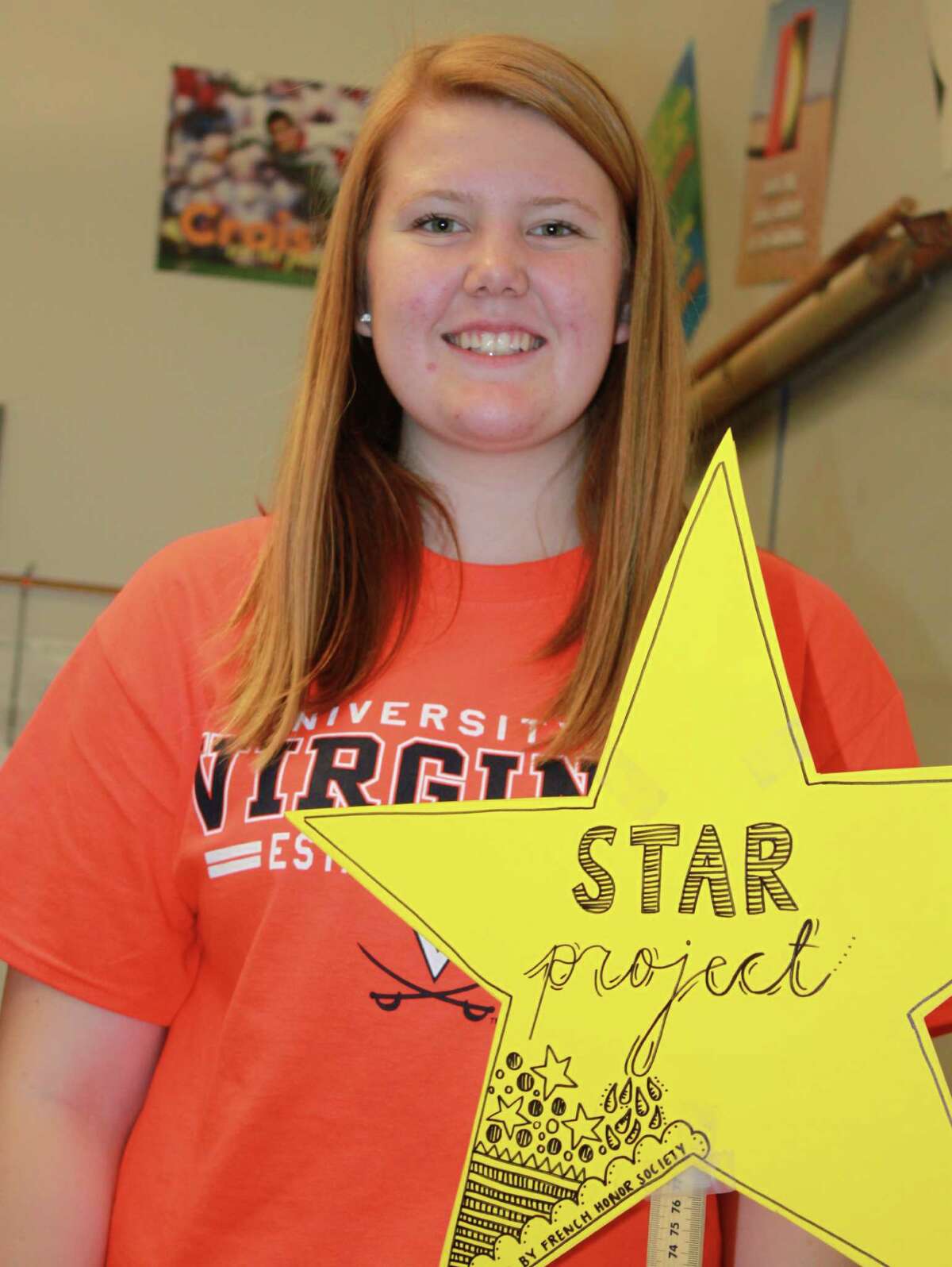 New Milford High School French Honor Society Star Project Chairperson Abigail Gillin proudly holds up the Star Project sign at the school.