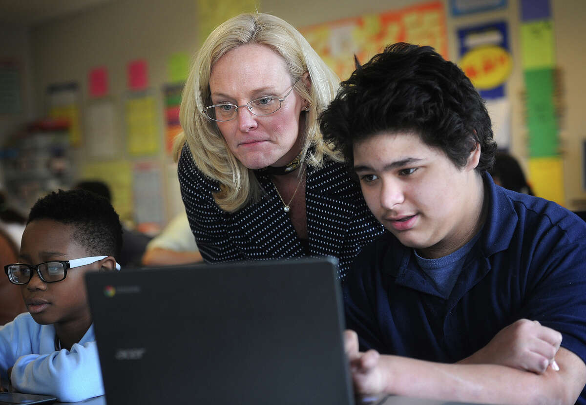 Sixth grader teacher Kathy Cunningham and student Jayvan Marrero, 12, review the format of the new common core standardized test, which will be taken online, at Jettie Tisdale School in Bridgeport, Conn. on Tuesday, March 10, 2015.