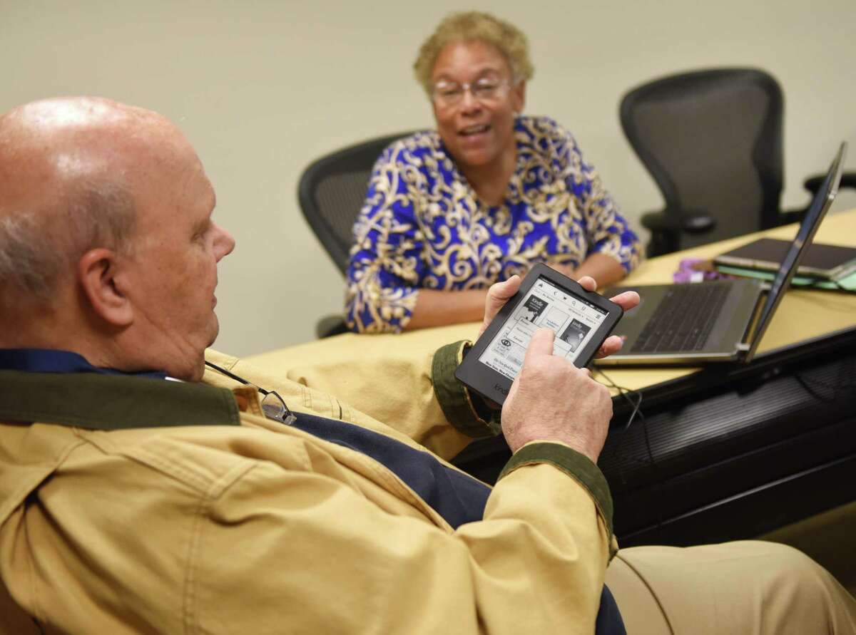 Riverside resident Charlie Graves gets help from training services librarian Jasmine Posey during the walk-in eBook tutorial at Greenwich Library Thursday. The Greenwich Library offered assistance to eBook users, helping people set up and learn how to use and check out books on their devices.