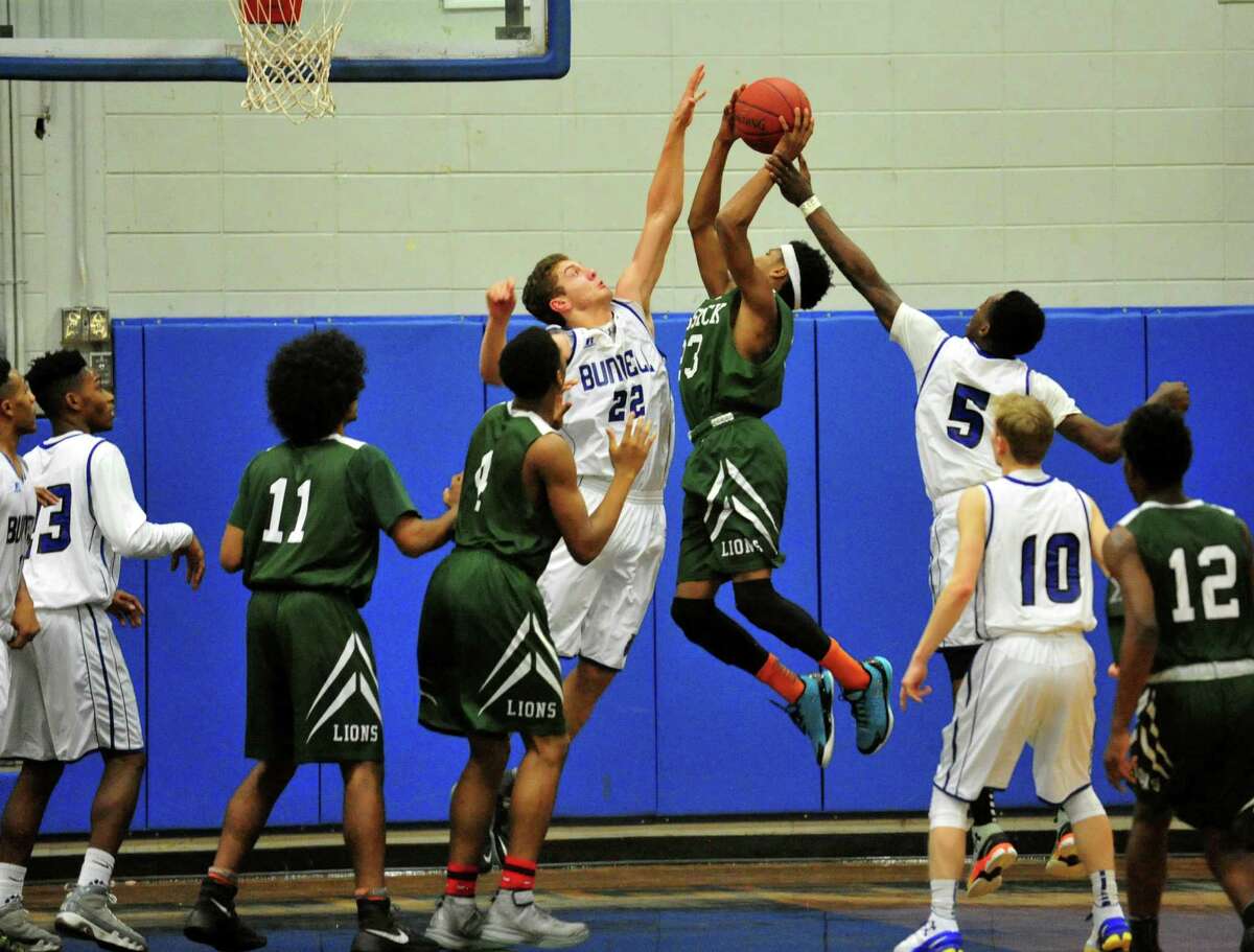 Bassick's Kevin Crawford gets blocked at the basket by Bunnell's Nicholas Giannoni (22) and Rashaad Spain (5) during basketball action in Stratford, Conn., on Thursday Jan. 7, 2016.
