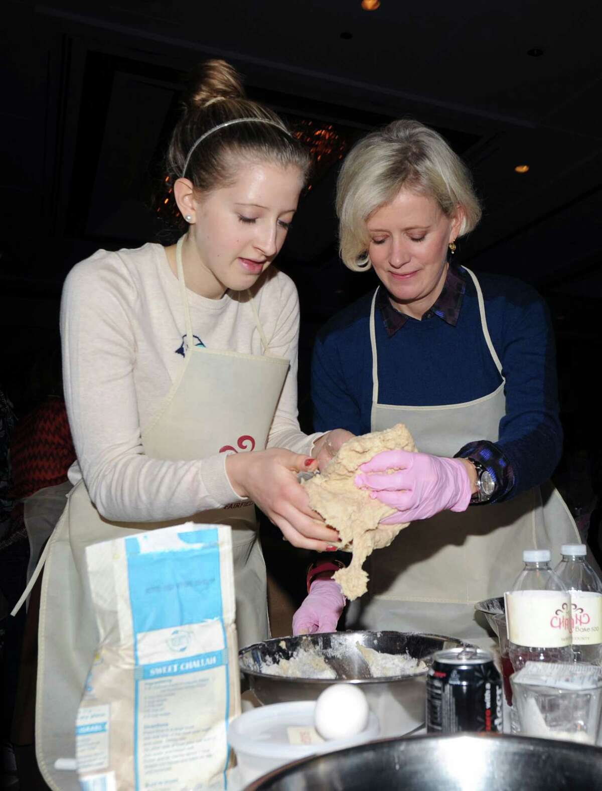 Below, Sophie Liebergall and her mother, Anne Liebergall, of New Canaan, knead challah dough together.