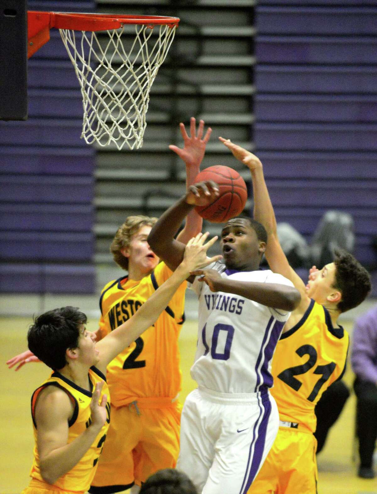 Westhill’s Tyrell Alexander is fouled while battling for the ball with Weston’s Andrew Folger (3), Chris Hover (2) and Hamilton Forsythe (21) during the Vikings’ 66-42 victory Thursday.