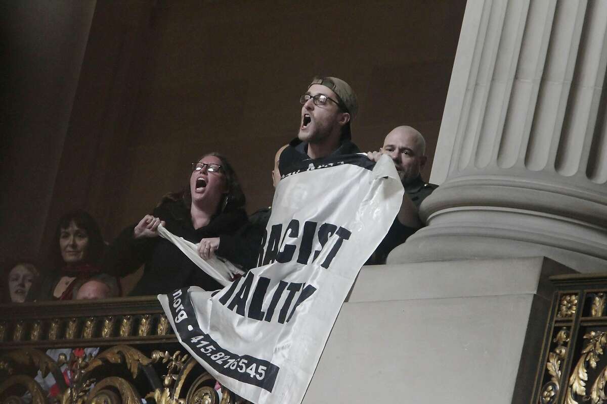 Protesters are removed as they hold a banner during the Inauguration of Mayor Lee at City Hall on Friday, January 8, 2015 in San Francisco, Calif.