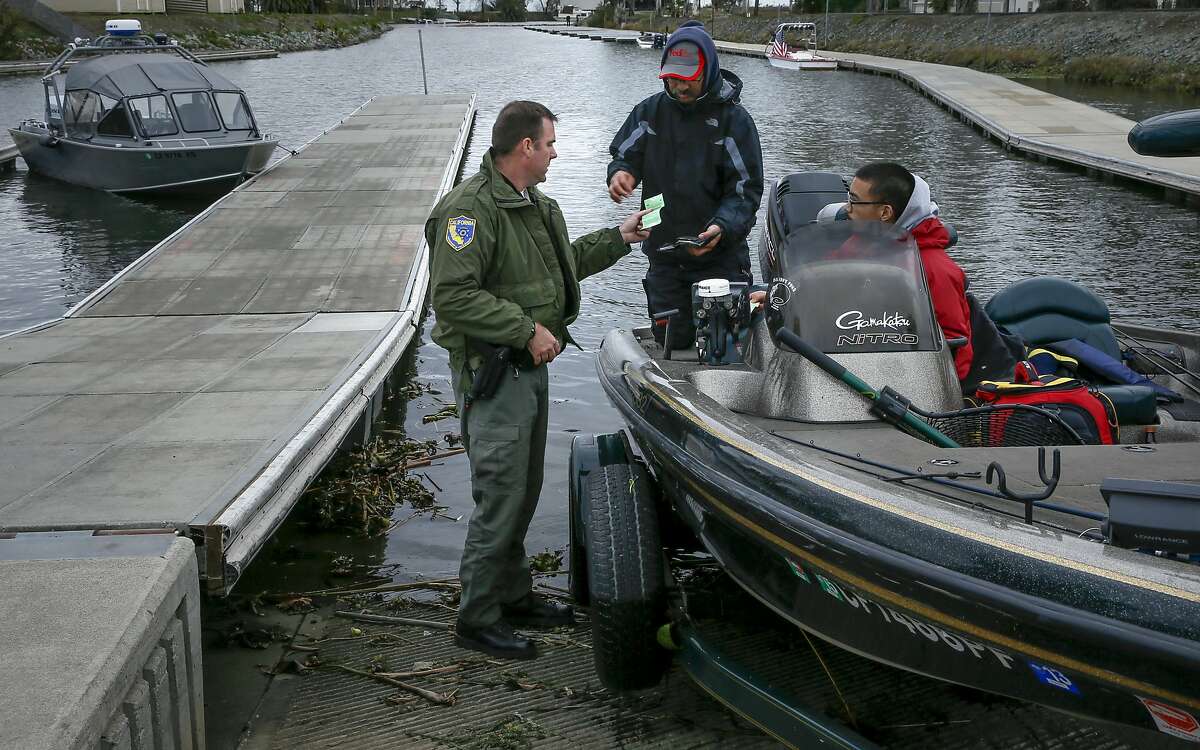 California Department of Fish and Wildlife Warden Clint Garrett checks fishing licenses at Orwood Marina during patrols on the California Delta near Brentwood, Calif. on Sat. January 9, 2016,