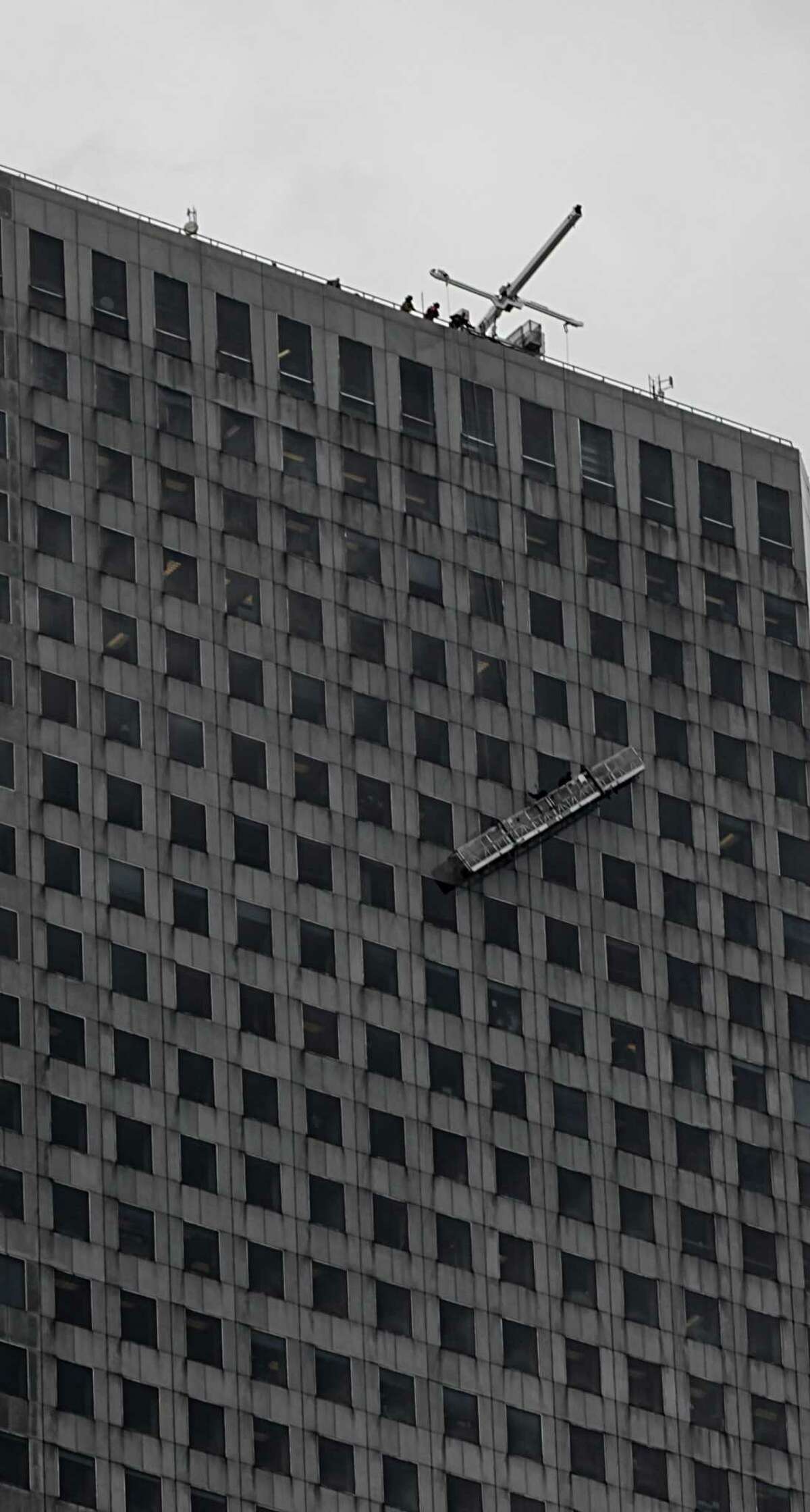 Houston Fire Department firefighters during a high rescue of window washer on the Chase Tower Monday, Jan. 11, 2016, in Houston.