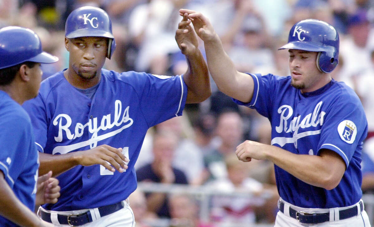 In this 2000 file photo, Kansas City Royals Jermaine Dye, left, and Mark Quinn, right, congratulate each other after scoring on a single by Todd Dunwoody in a game against the Chicago Cubs at Kauffman Stadium.