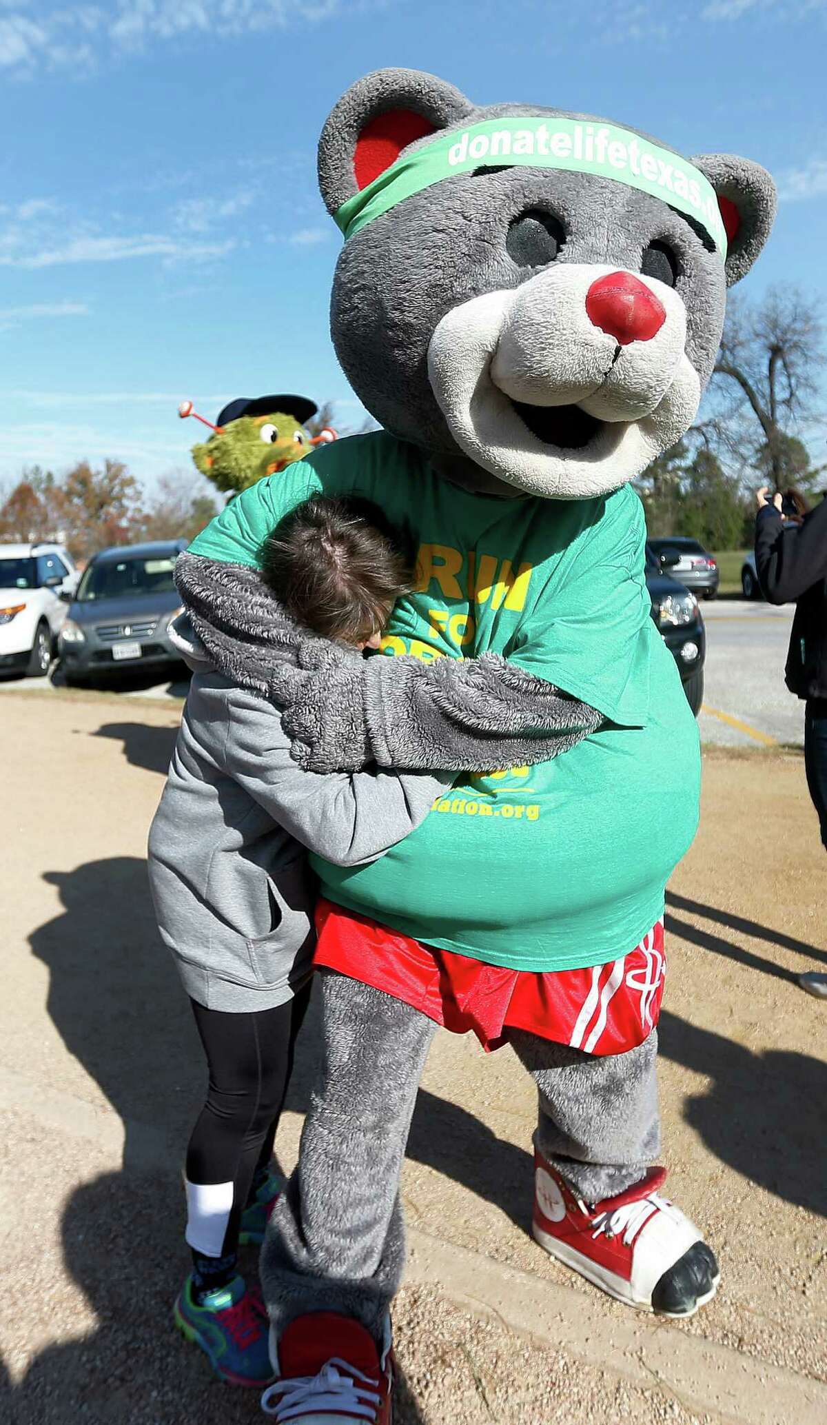 Rockets mascot, Clutch, hugs Sarah Pepper, the Hot 95.7 morning show host and the Aramco Houston Half Marathon Ambassador during the Houston Marathon Committee's annual "Why I Run" media day at Memorial Park on Monday, Jan. 11, 2016, in Houston.