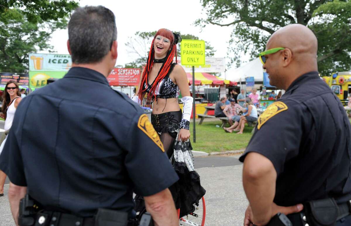 Sasha the Fire Gypsy talks with Bridgeport Police officers Friday, Aug. 1, 2014, at the annual Gathering of the Vibes music festival at Seaside Park in Bridgeport, Conn.