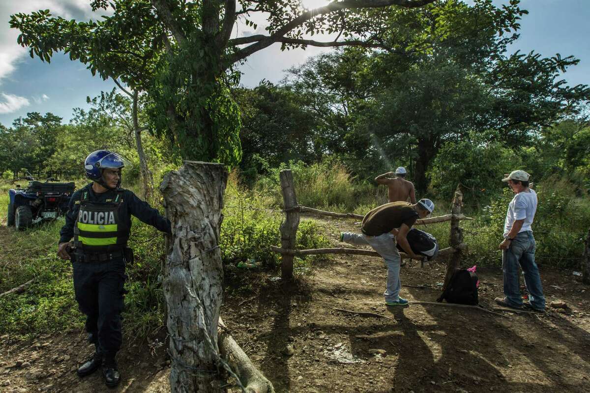 A Costa Rican police officer watches as migrants cross into Nicaragua near Penas Blancas, Costa Rica, Jan. 6, 2016. Thousands of Cubans attempting to reach the U.S. border via Central America have been stranded in shelters in Costa Rica, but a political deal could have them soon back on the trail, and U.S. law gives them special status to apply for green cards. (Meridith Kohut/The New York Times)