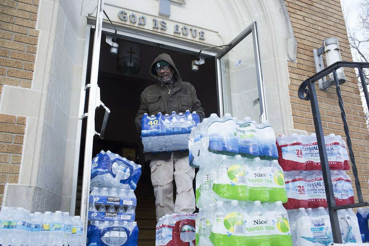 Maurice Rice organizes cases of water at the Joy Tabernacle Church on Monday, Jan. 11, 2016, in Flint, Mich. Michigan Gov. Rick Snyder pledged Monday that officials would make contact with every household in Flint to check whether residents have bottled water and a filter and want to be tested for lead exposure while his embattled administration works on a long-term solution to the city's water crisis.